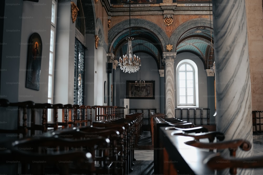 a church with pews and a chandelier hanging from the ceiling