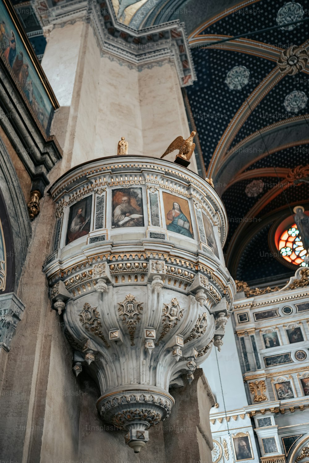 a statue of a bird on top of a pillar in a church