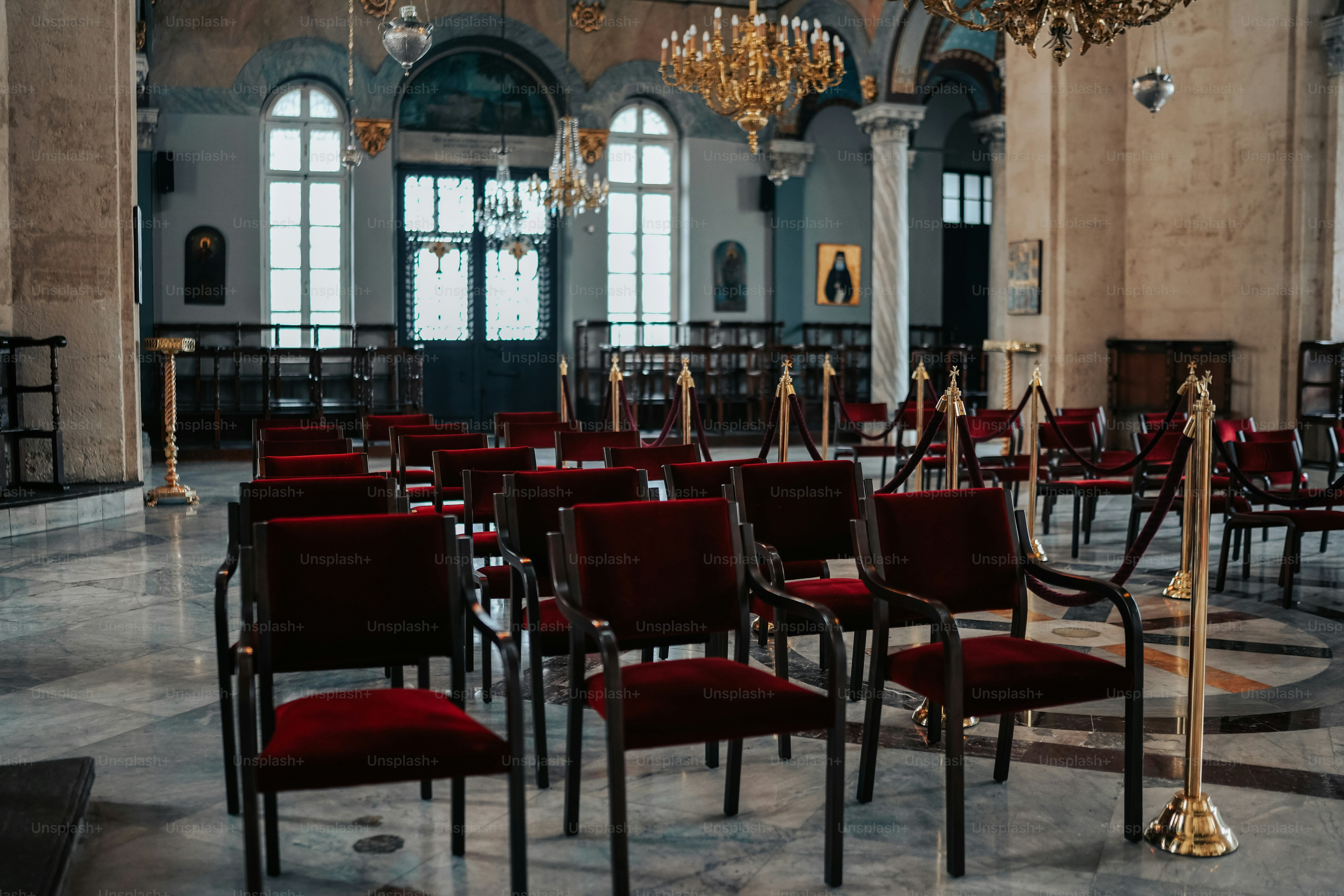 a room filled with red chairs and chandeliers