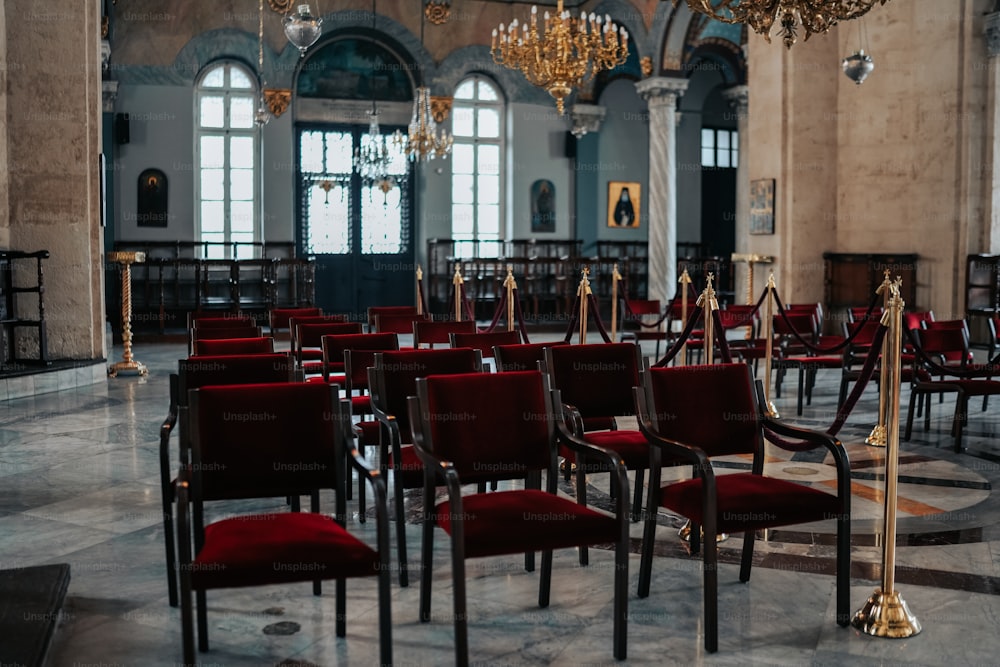 a room filled with red chairs and chandeliers
