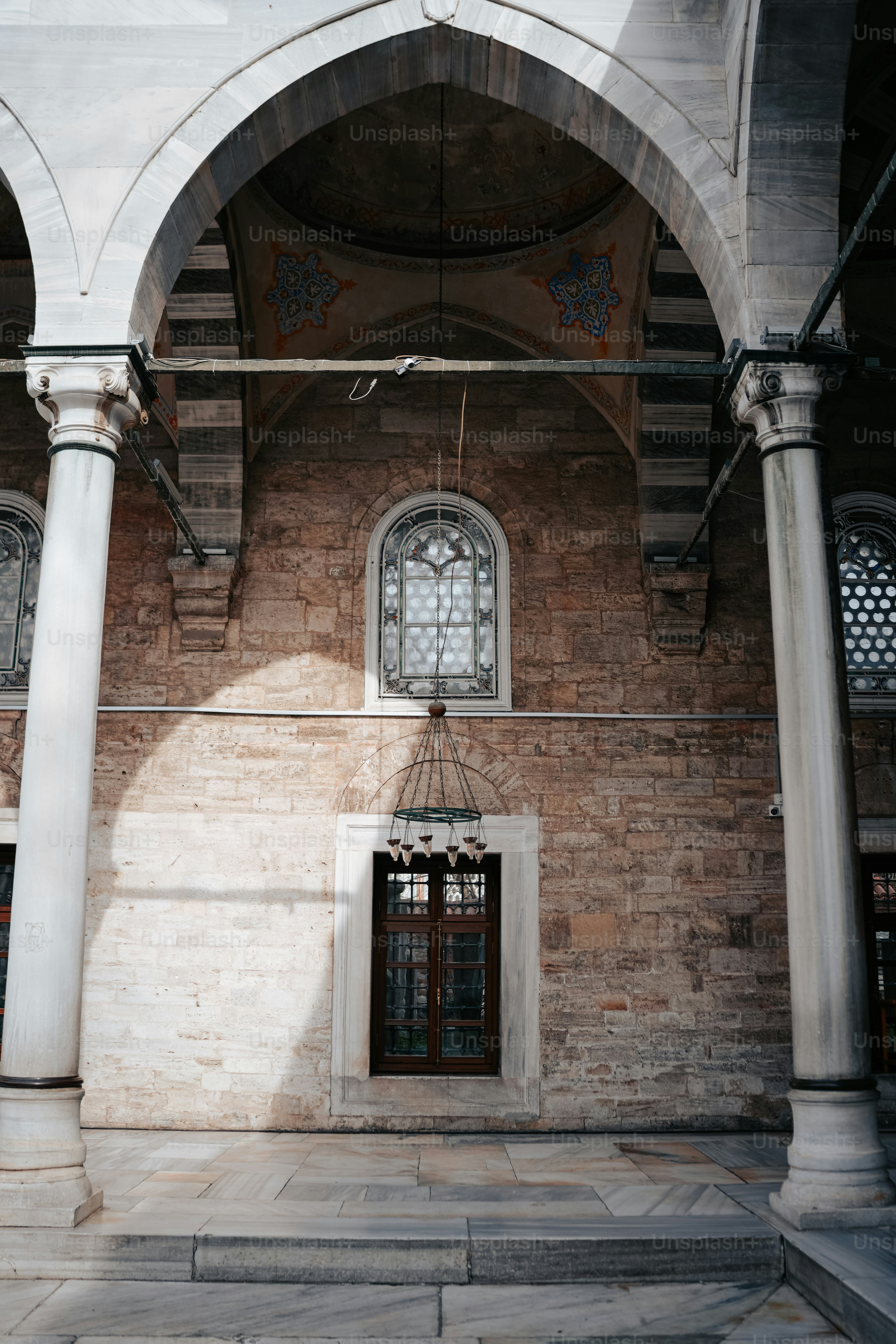 2つのアーチ型の窓とドアのある石造りの建物