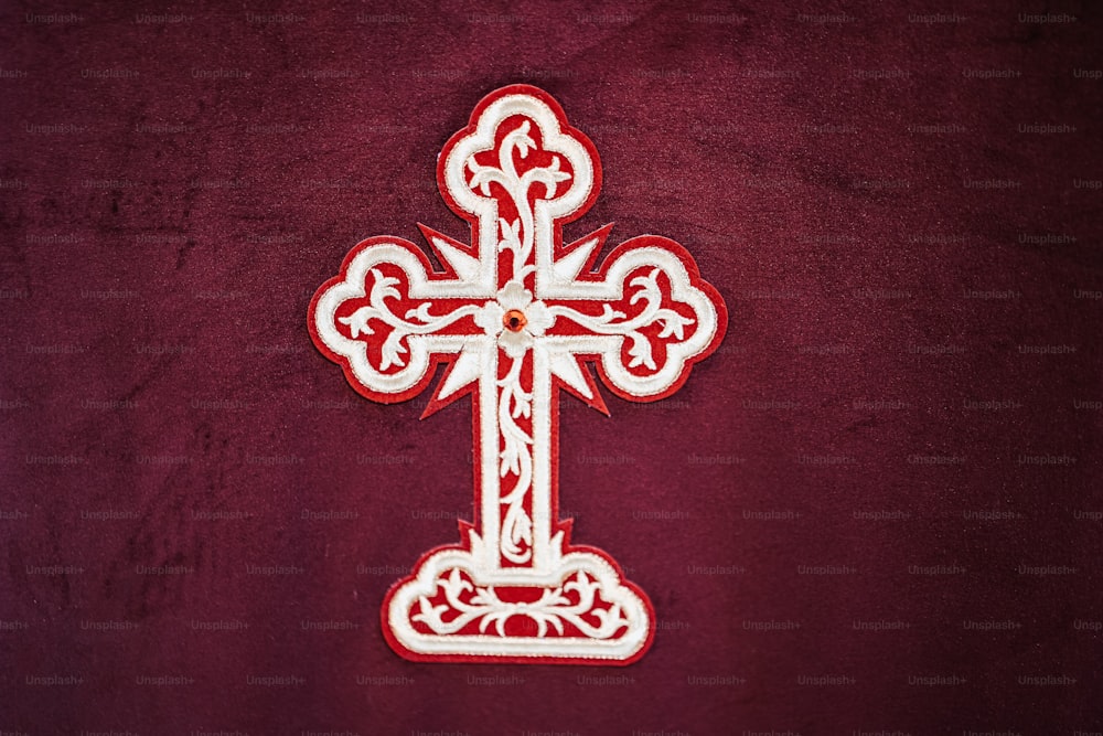 una cruz roja y blanca sobre fondo rojo