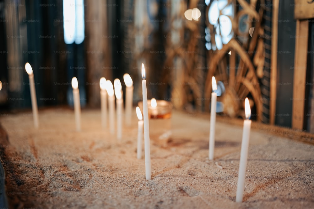 a bunch of white candles that are on a table