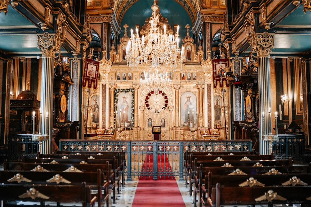 a church with a chandelier and a red carpet