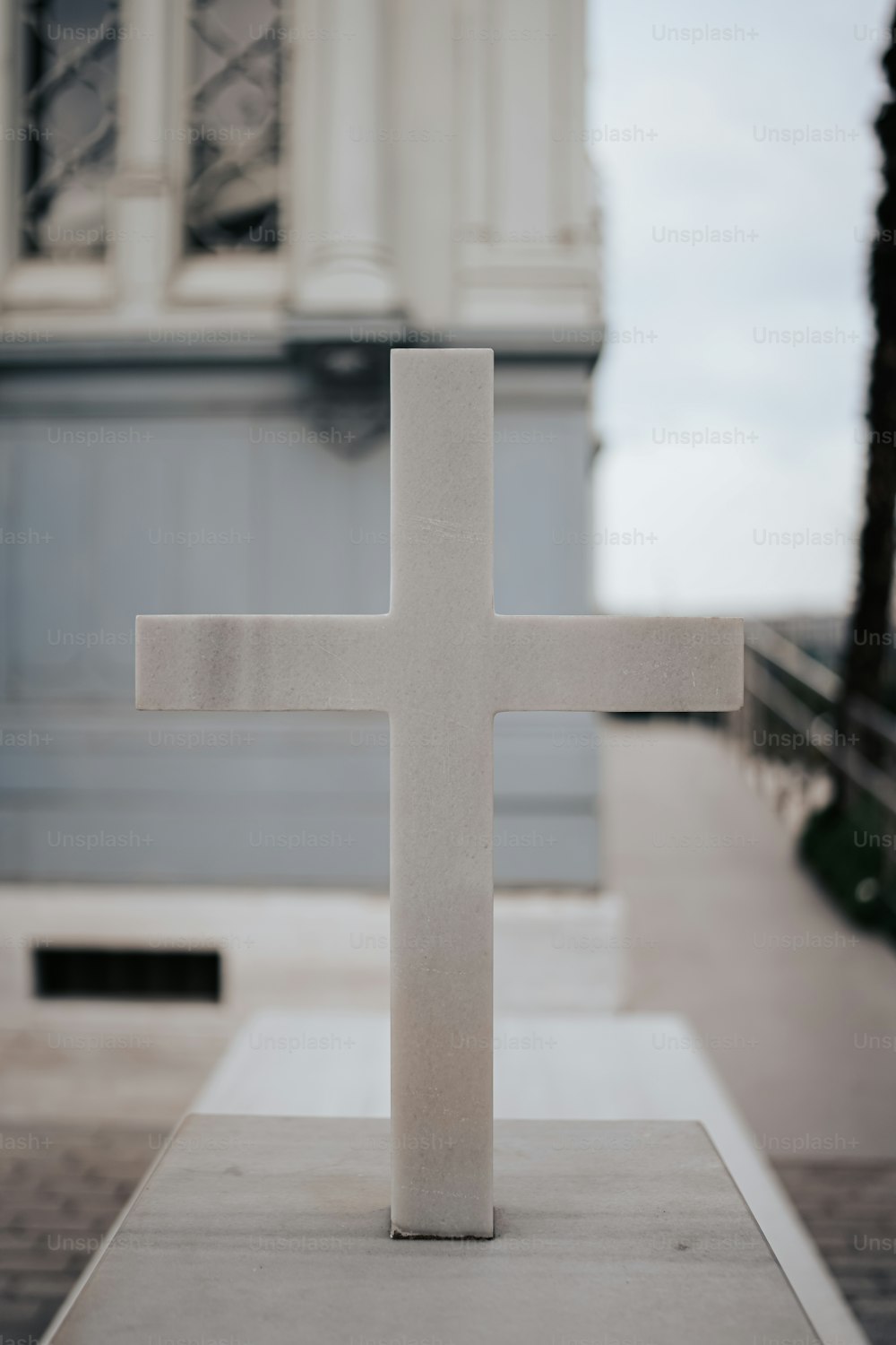 a white cross sitting on top of a cement slab