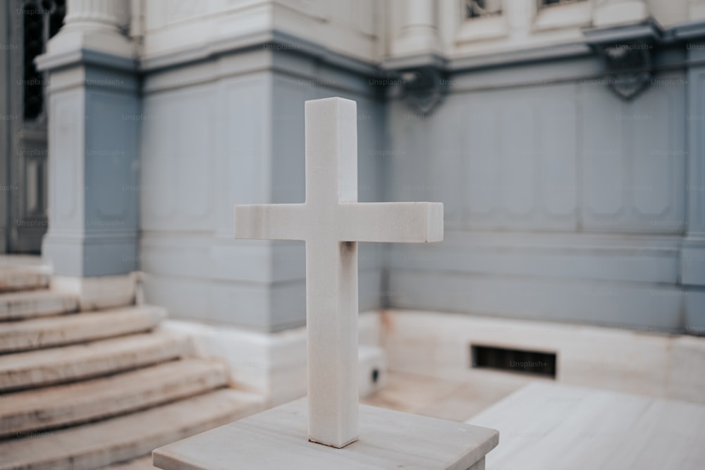 uma cruz branca sentada em cima de uma mesa de madeira