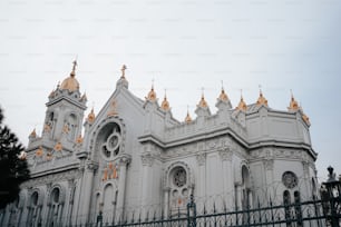 a white and gold building with a fence around it