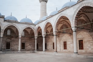 a building with arches and a clock tower in the background