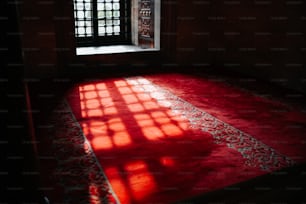 a room with a red rug and a window