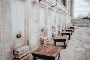 a row of wooden benches sitting next to a building