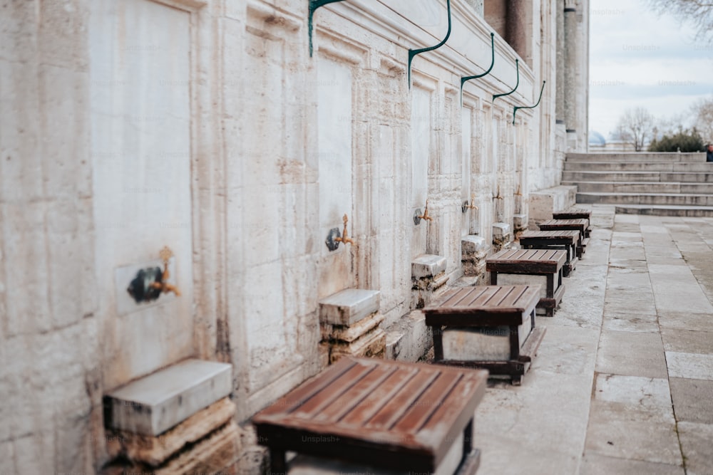 a row of wooden benches sitting next to a building