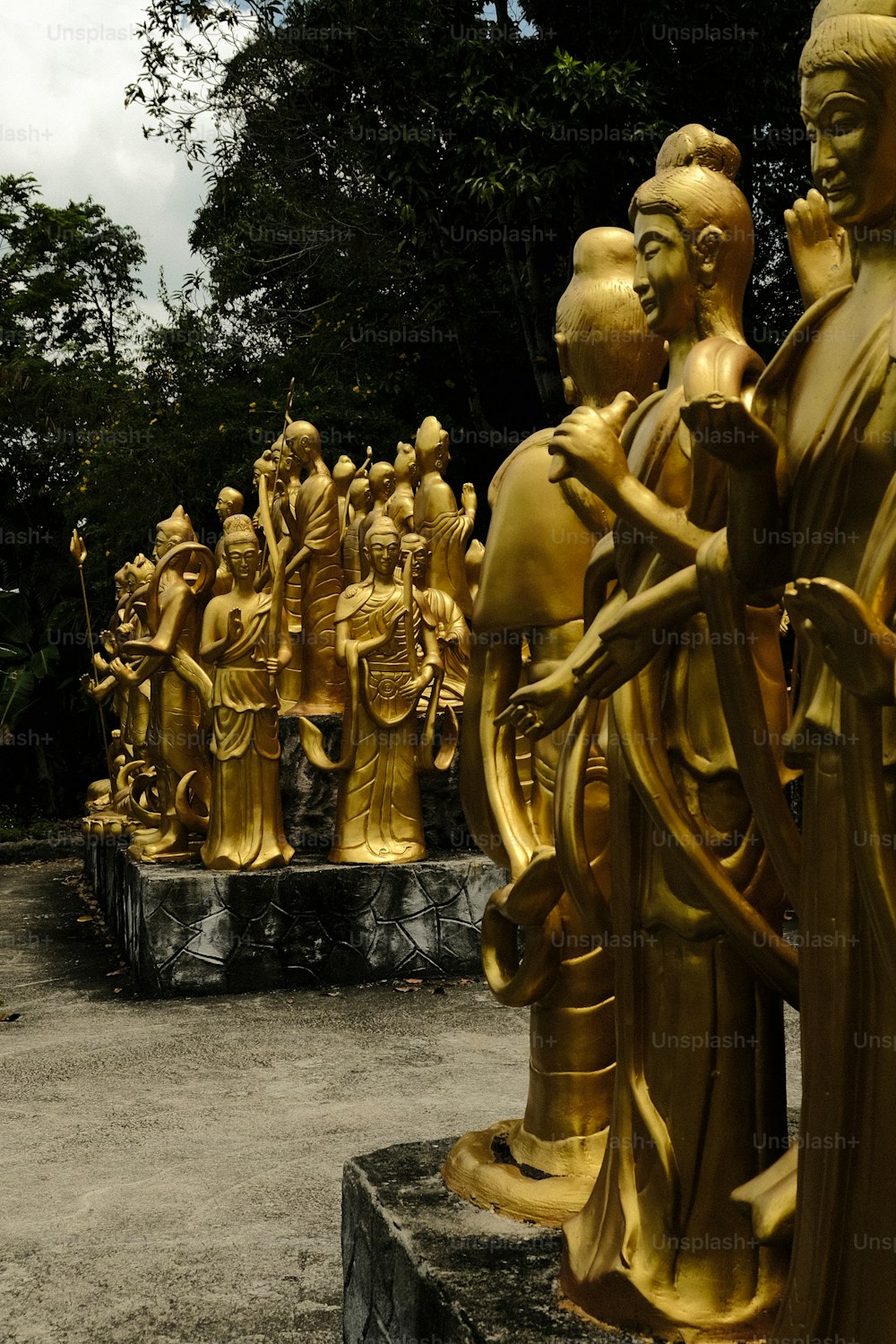 隣り合って座っている黄金の彫像のグループ