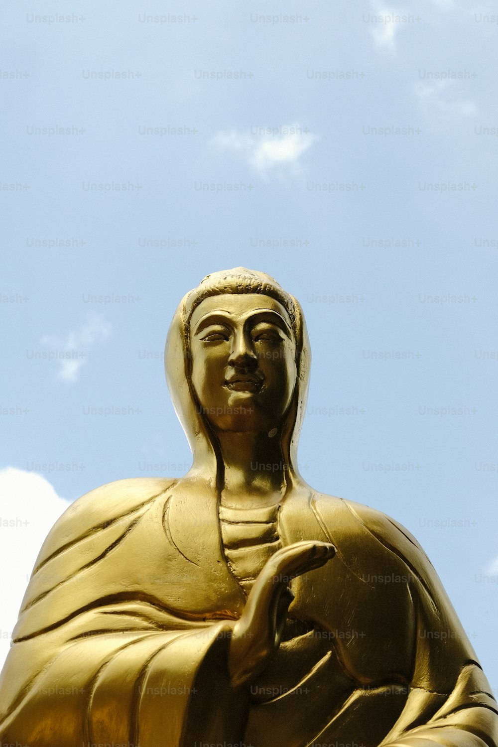 Une statue de Bouddha dorée avec un ciel bleu en arrière-plan