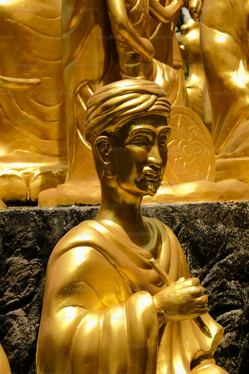 a golden statue of a woman holding a flower