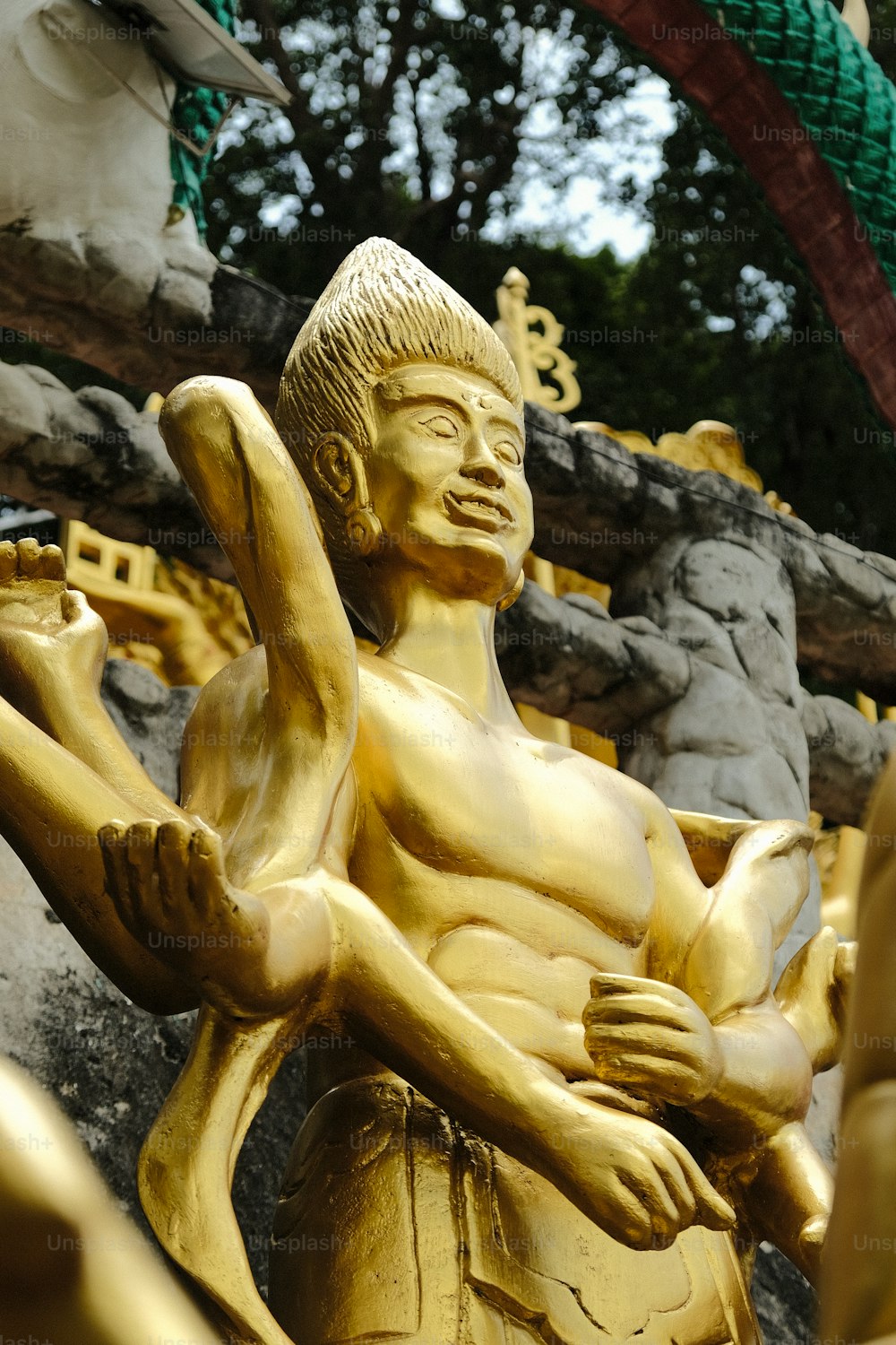 a gold statue of a person holding a bird