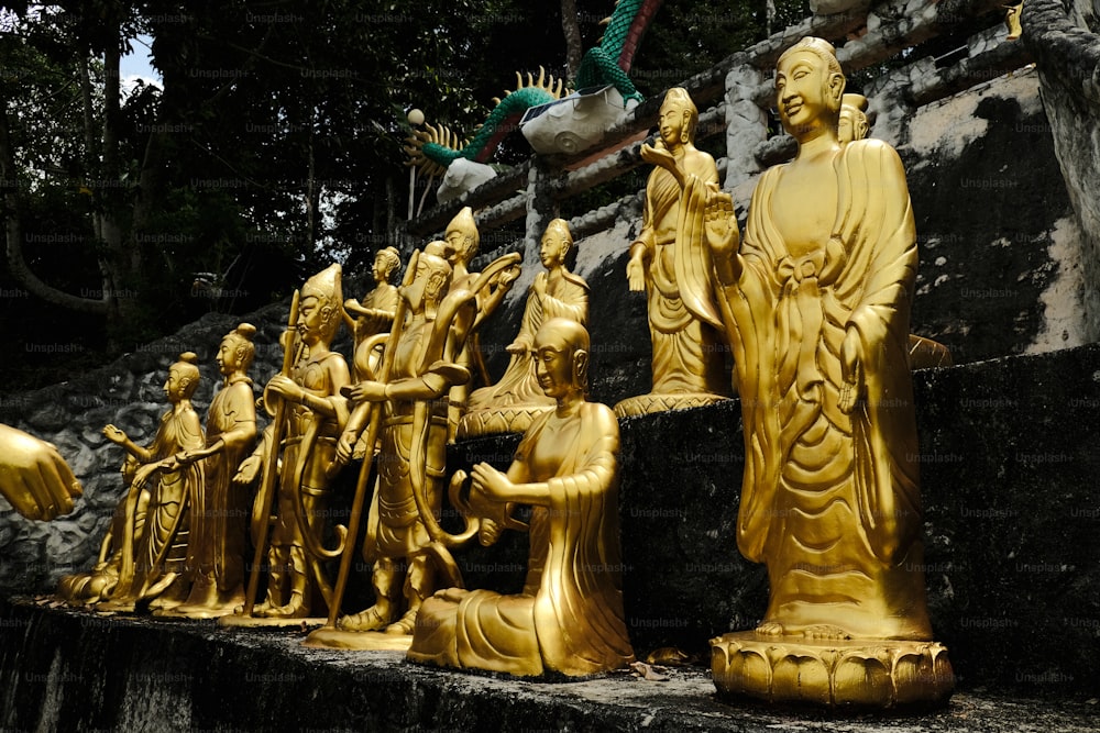 eine Gruppe goldener Statuen, die nebeneinander sitzen