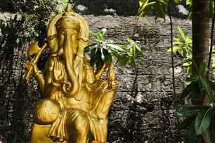 a golden statue of an elephant in a garden