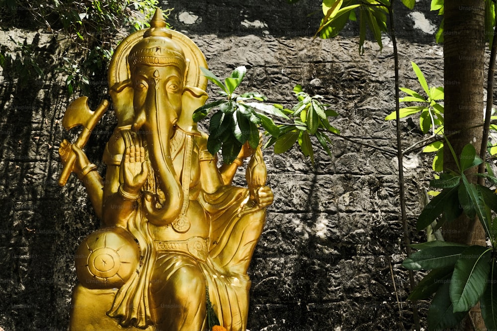 Una estatua dorada de un elefante en un jardín