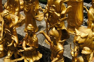 Un grupo de estatuas de oro sentadas encima de un piso de piedra