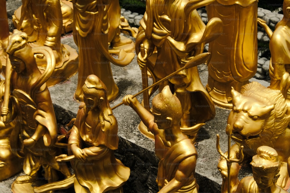 um grupo de estátuas de ouro sentadas no topo de um piso de pedra