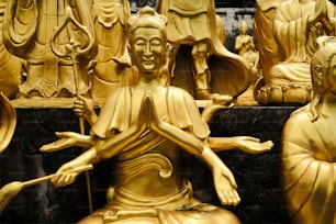 Une statue de Bouddha entourée d’autres statues
