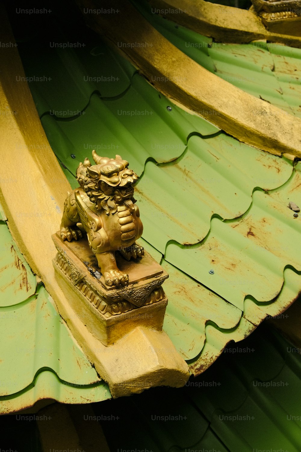 Eine Statue eines Löwen auf einem grünen Dach
