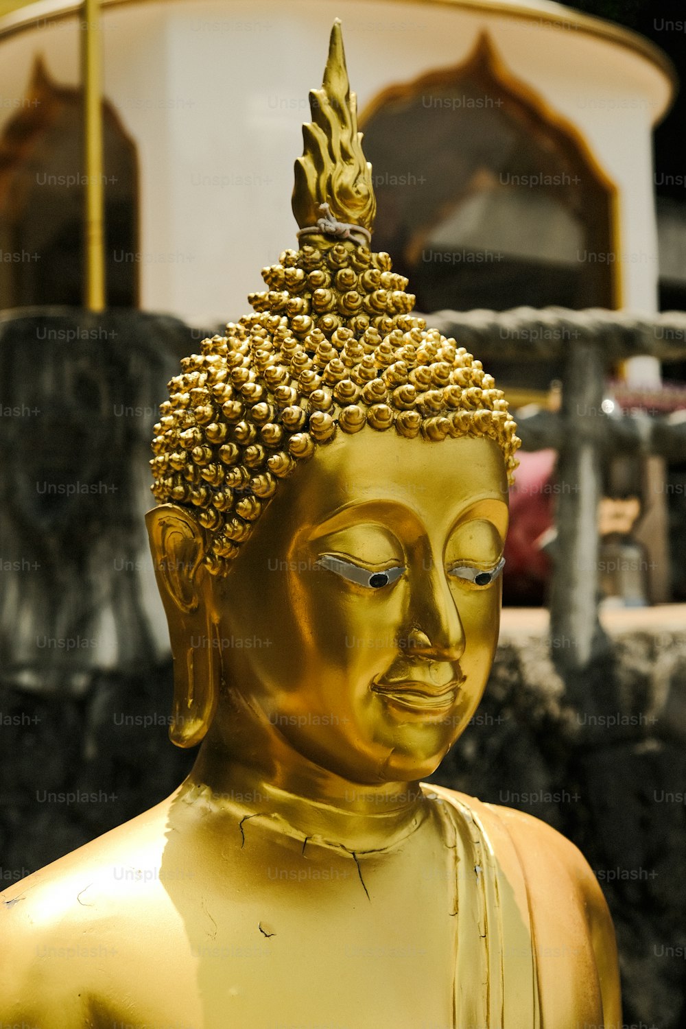 une statue de Bouddha doré assise devant un bâtiment