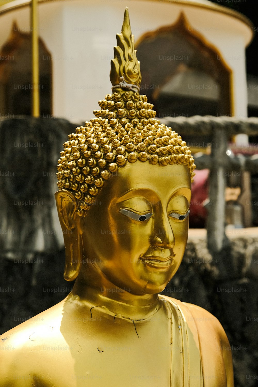 a golden buddha statue sitting in front of a building