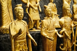 un groupe de statues en bois sculpté assises les unes à côté des autres