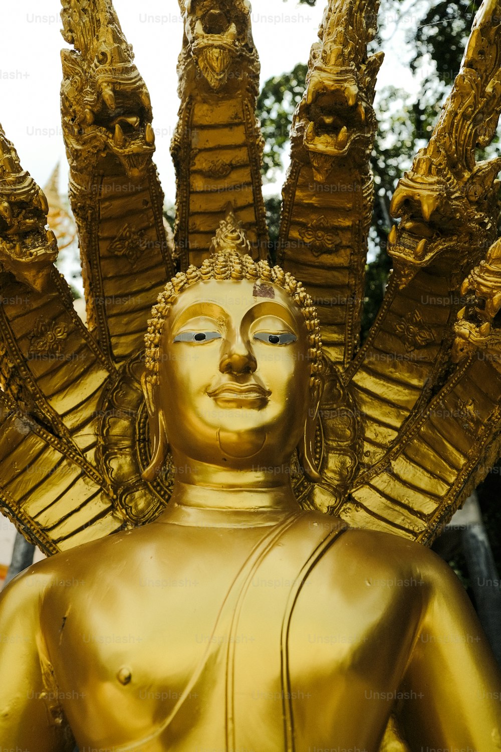 Una estatua dorada de una persona con muchos brazos extendidos