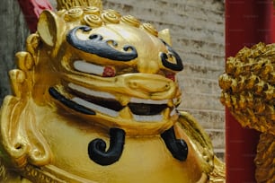 a gold statue of a lion with a red background