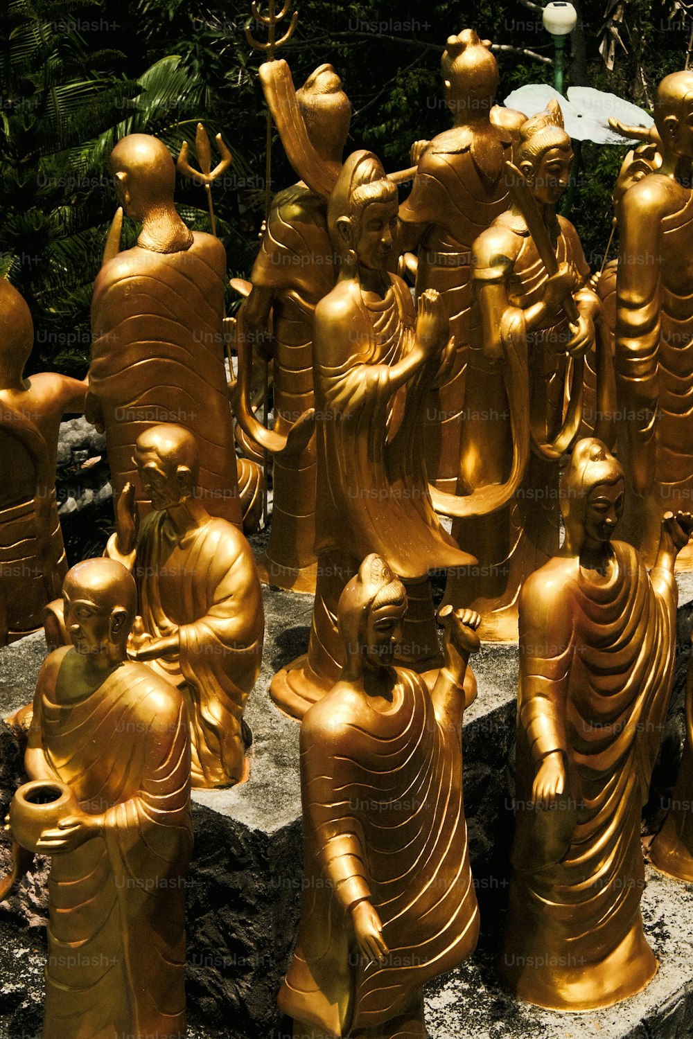 a group of golden buddha statues sitting on top of a rock