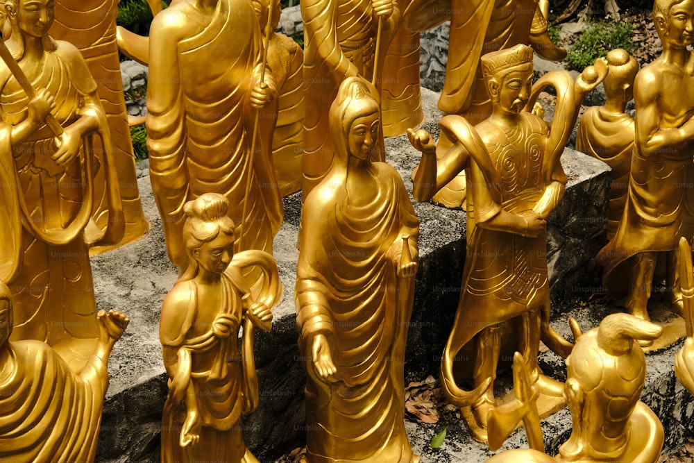 um grupo de estátuas douradas de Buda sentadas uma ao lado da outra