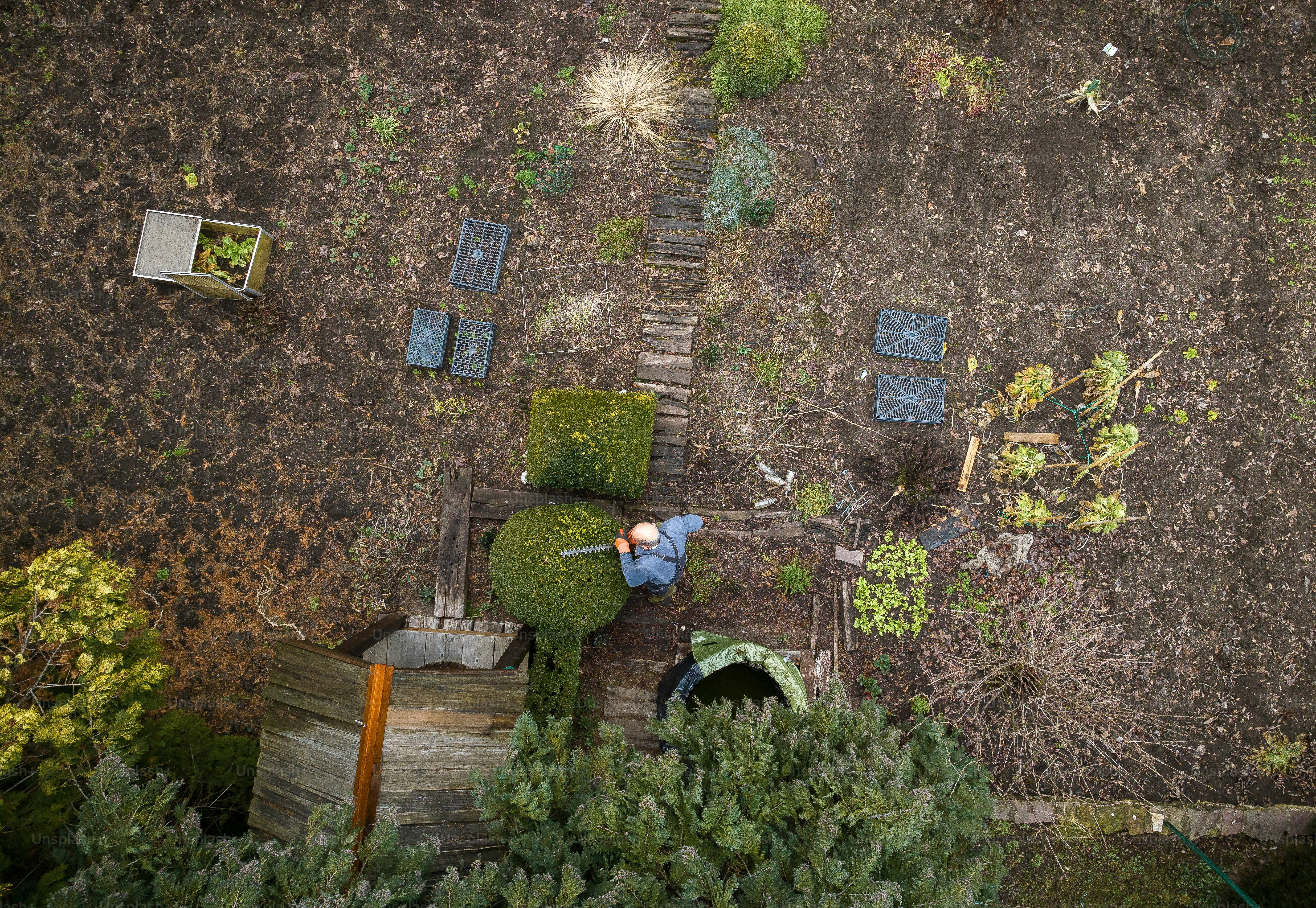 an aerial view of a man working in a garden