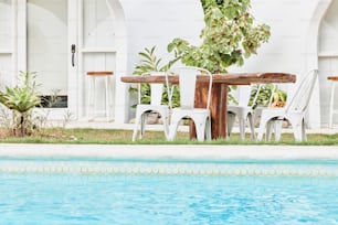 a table and chairs sitting next to a swimming pool