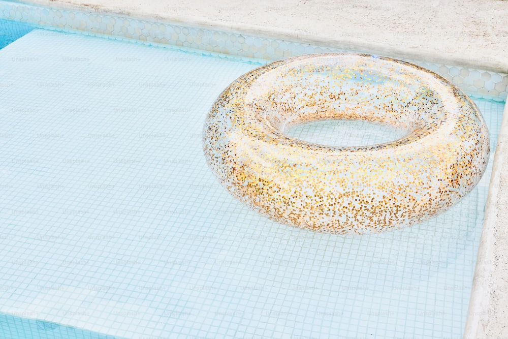 a donut sitting on top of a swimming pool