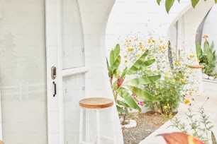 un taburete de madera sentado junto a una puerta blanca