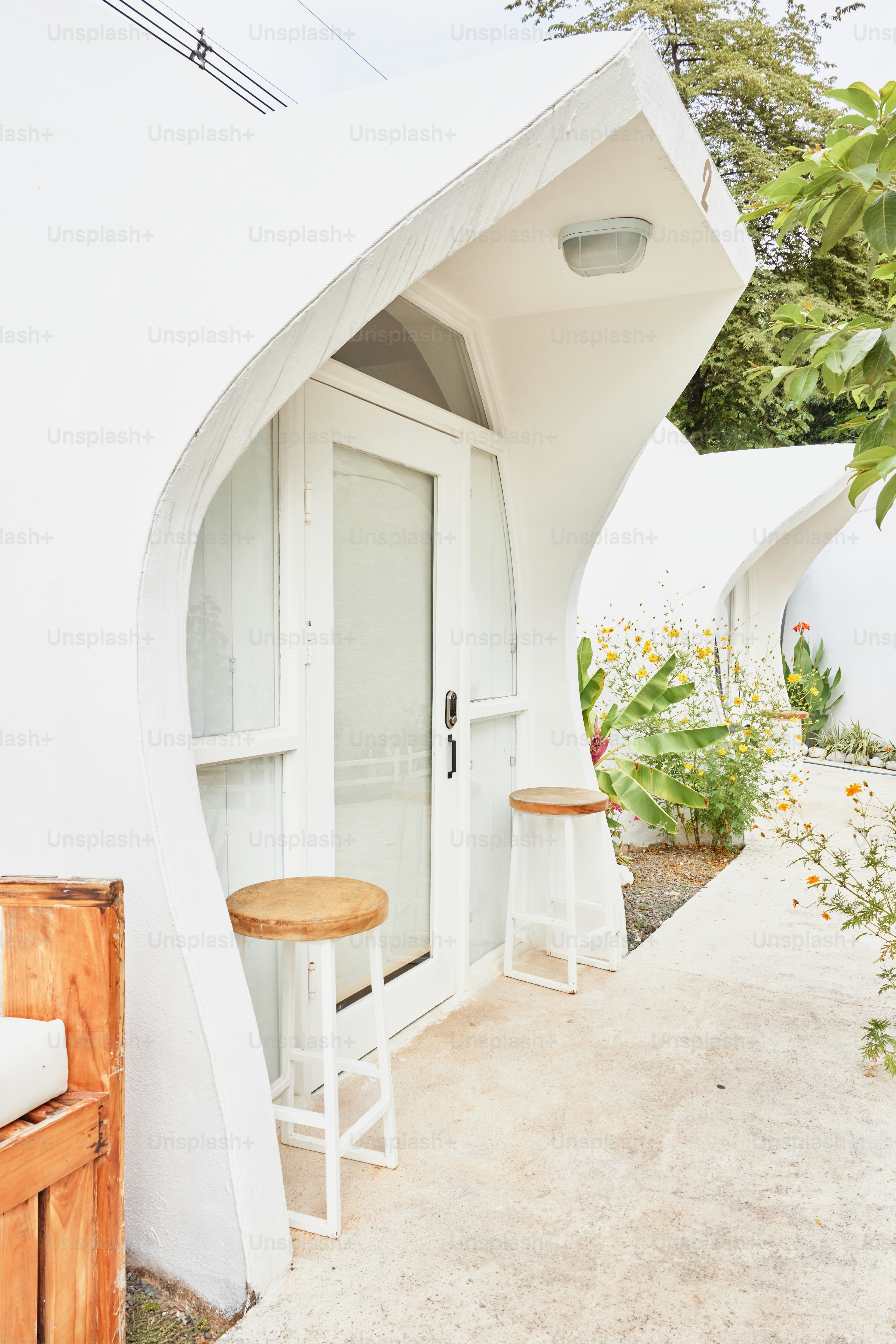 a white building with two stools outside of it