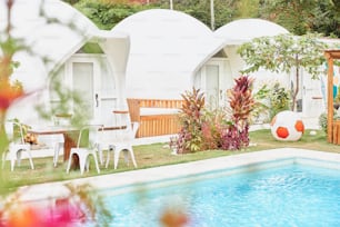 a backyard with a swimming pool and some chairs