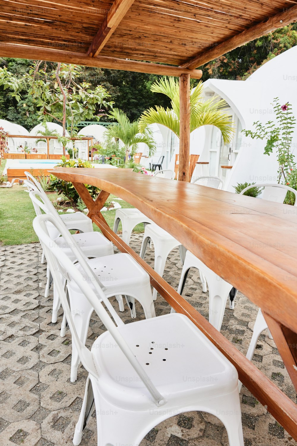 a long wooden table sitting under a wooden roof