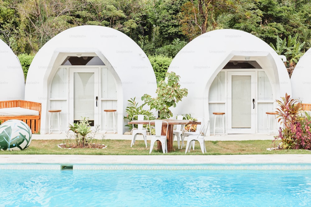 a couple of white buildings sitting next to a swimming pool