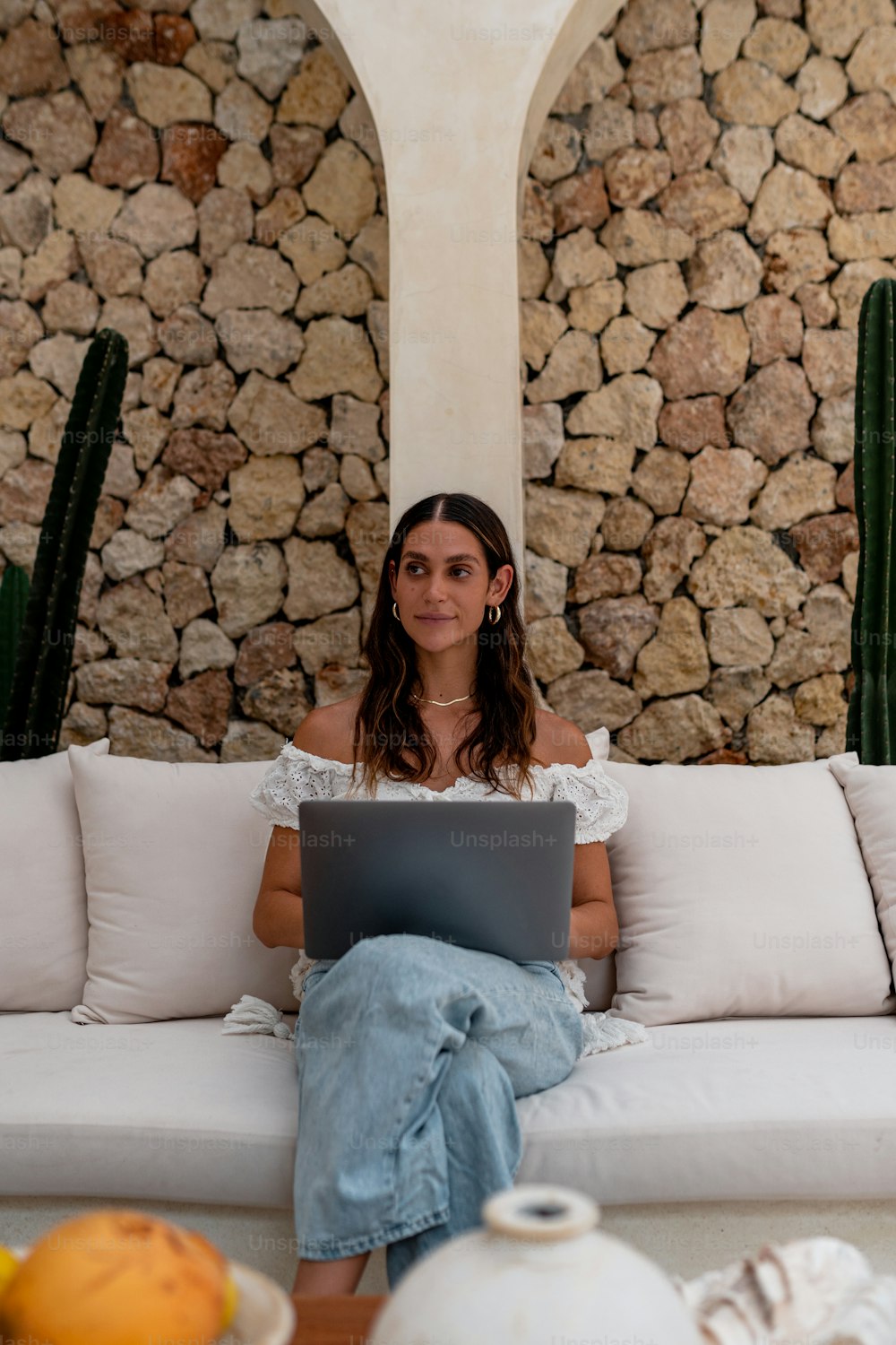 Une femme assise sur un canapé avec un ordinateur portable