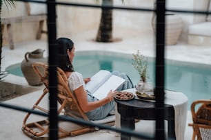 a woman sitting in a chair reading a book