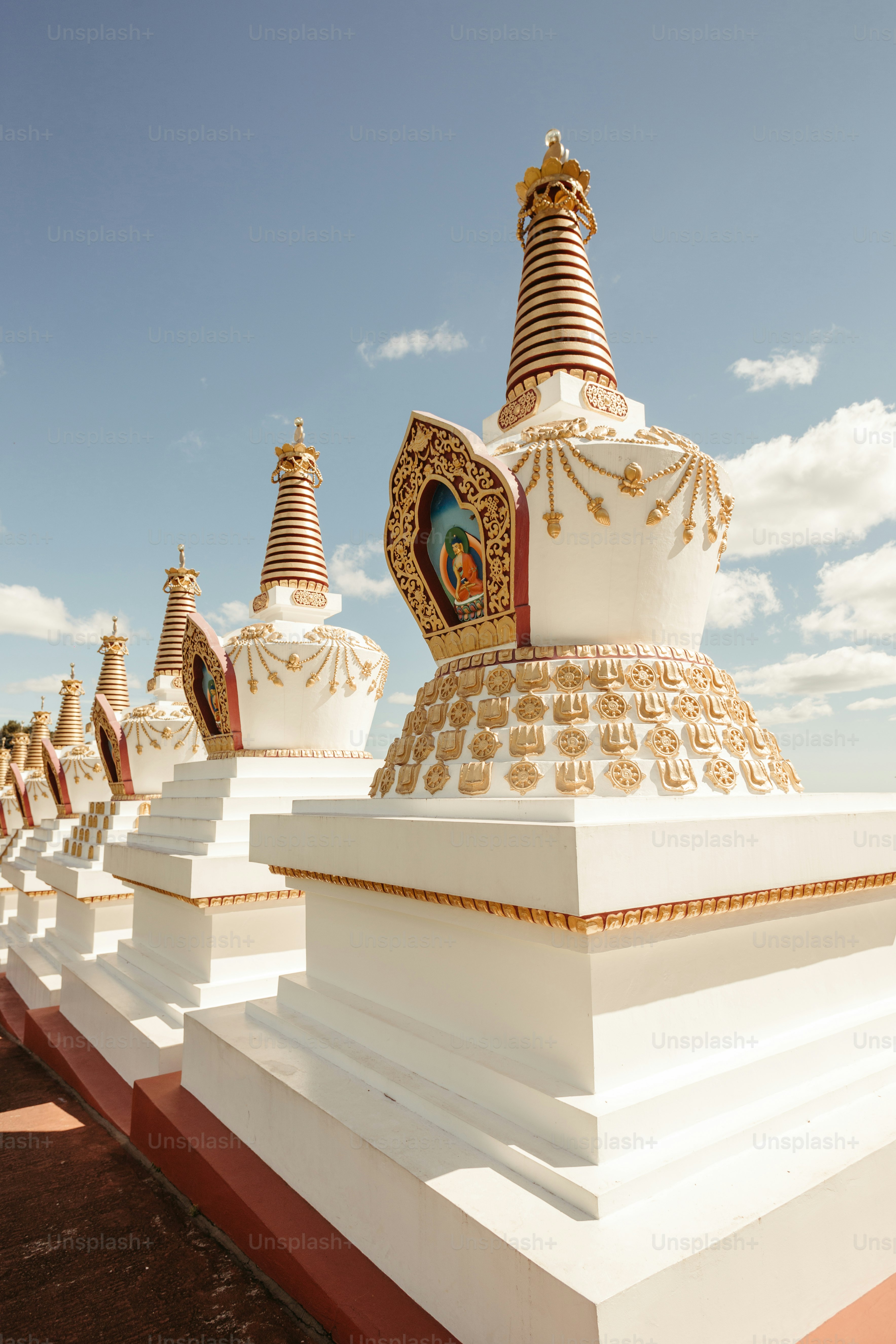 a row of white and gold statues on a sunny day