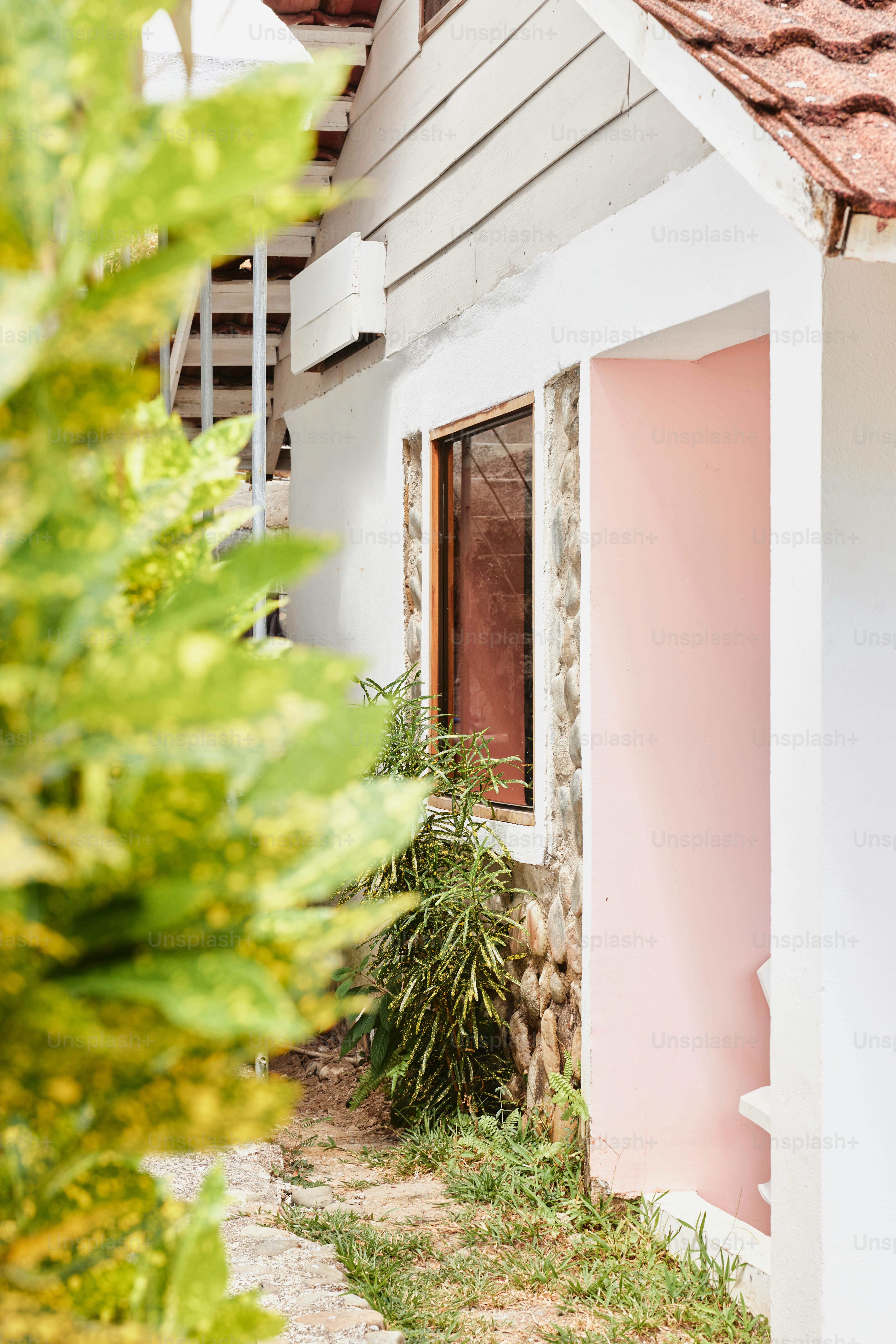 a small white house with a pink door