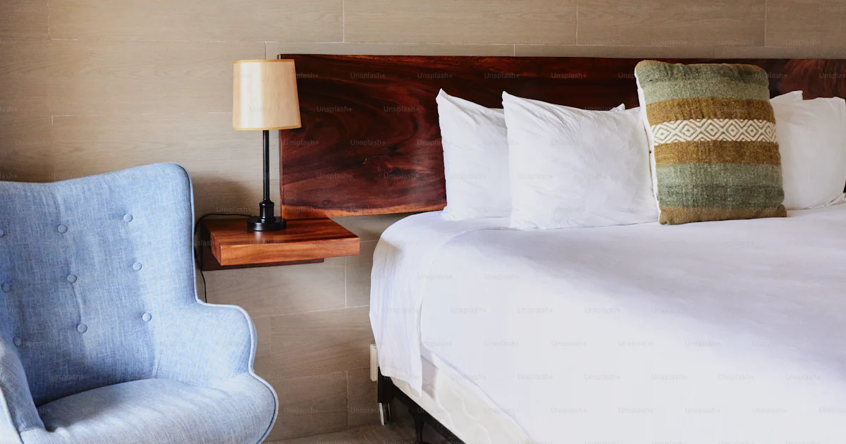 Foto Un dormitorio con una cama y una silla – Cómodo Imagen en Unsplash