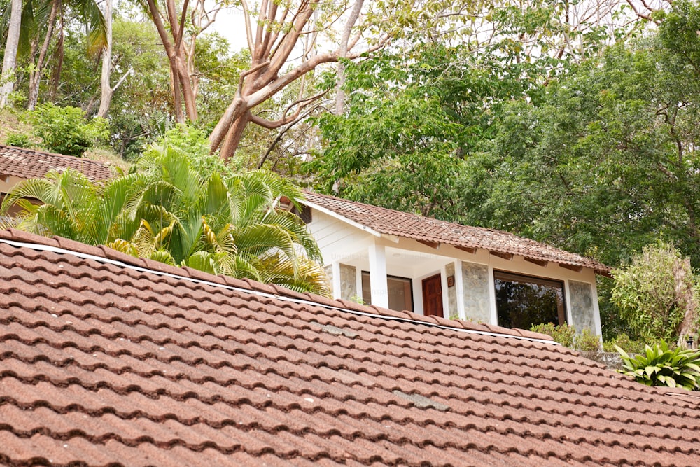 Una casa con un tetto rosso circondato da alberi