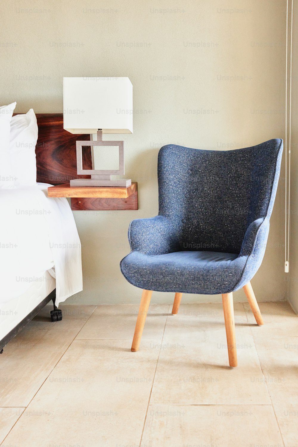 ein blauer Stuhl neben einem Bett in einem Schlafzimmer