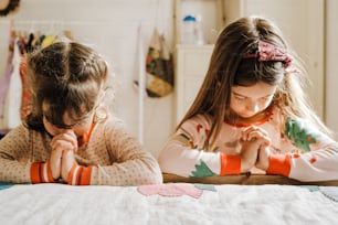 duas meninas sentadas em uma mesa juntas