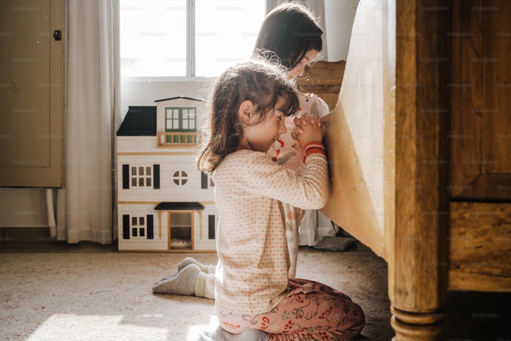 two little girls playing with a doll house